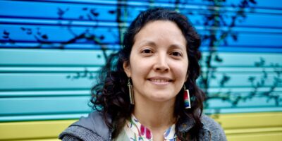 Gabriela Martínez mira a cámara mientras reflexiona sobre su identidad como migrante con la enfermedad esclerosis múltiple