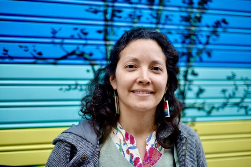 Gabriela Martínez mira a cámara mientras reflexiona sobre su identidad como migrante con la enfermedad esclerosis múltiple